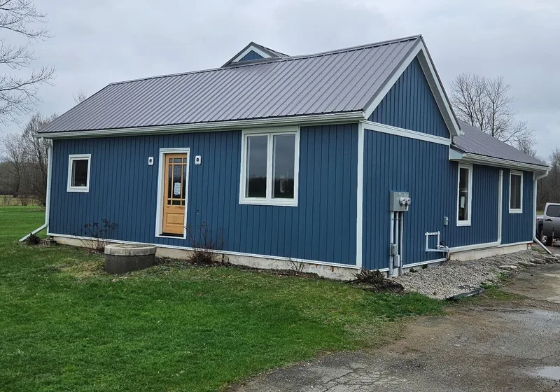 Blue exterior siding and white window trim on a single-storey home