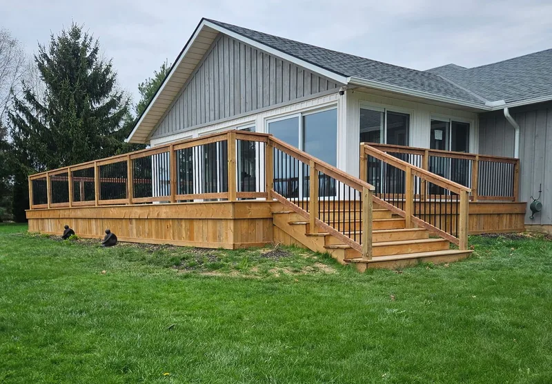 Finished deck, stairs and railing around a grey home