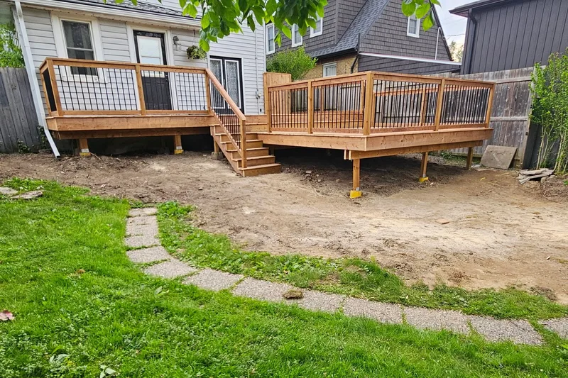 Wood deck with railing and stairs viewed from the backyard