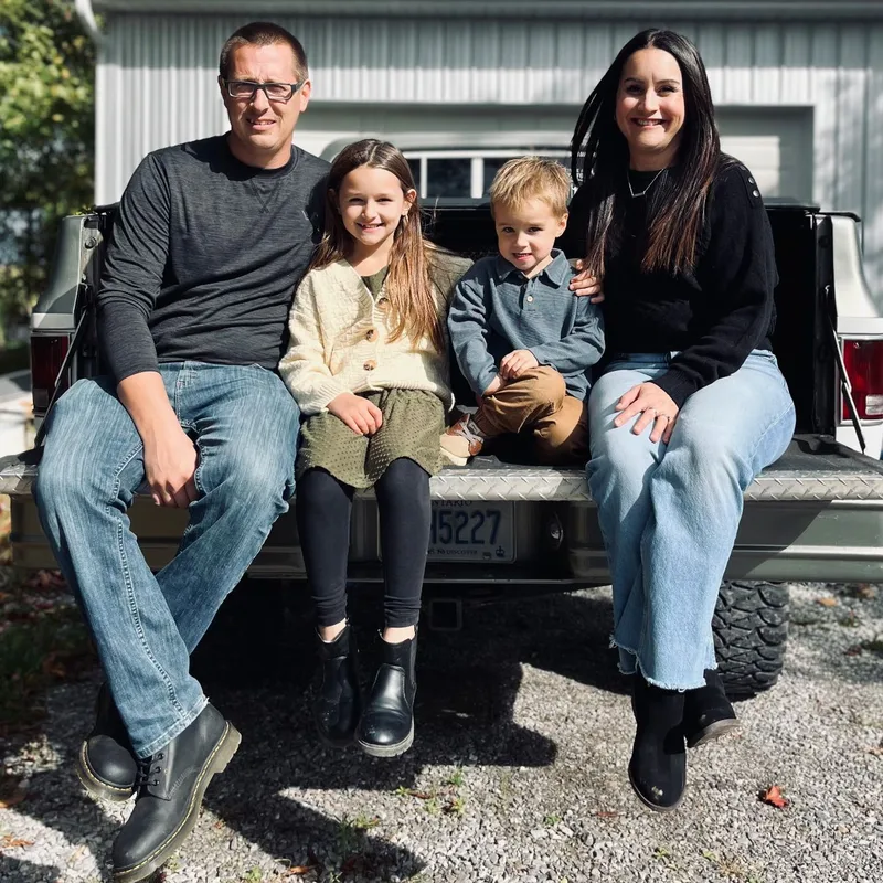 Jeremy and his family sitting together on a truck tailgate