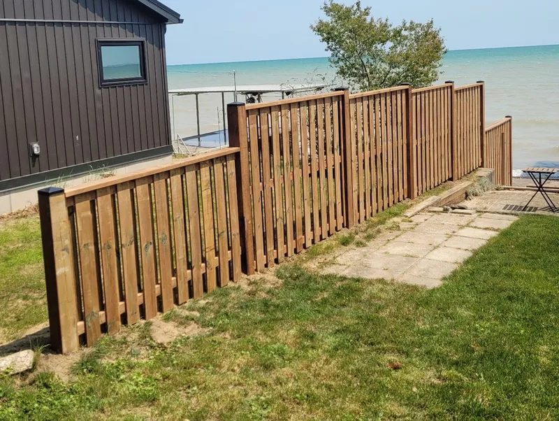 Stepped wood fencing beside a lakeside home