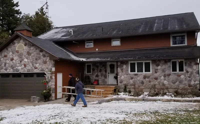 Stone-front home with brown siding and white exterior trim, photographed on a JerPro Construction project