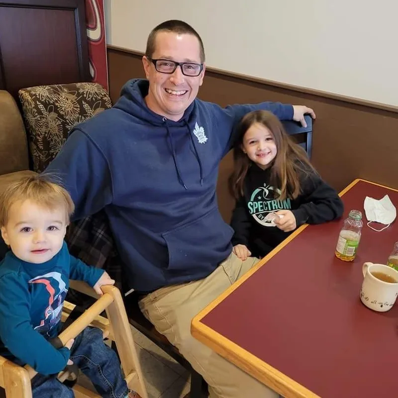Jeremy Proctor sitting with two children at a restaurant