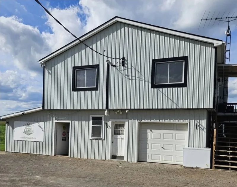 Two-storey building with vertical silver steel siding and black window trim